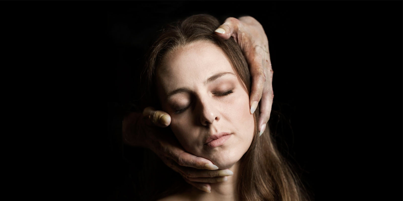 Kampanjbild Dom blinda. Kim Theodoridou Bergquist  blundar och två knotiga händer med långa naglar tar om hennes ansikte bakifrån.