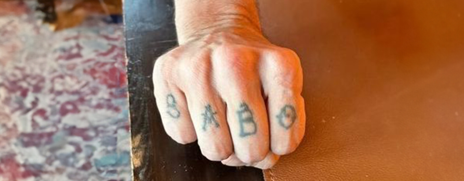 hand med bokstäverna BABO tatuerade på fingrarna